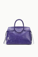 Purple croc-embossed carryall tote with top handles and side tassel ties