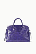 Purple croc-embossed carryall with structured top handles and side tassel ties