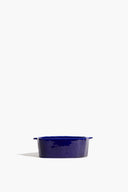 Small ceramic dog bowl, glossy dark blue with raised dog-face cutout