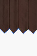 Dark brown linen placemats with pointed hem and blue trim, close-up