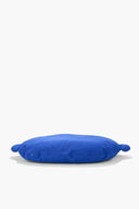 Blue plush floor pillow with rounded shape and small side ear details