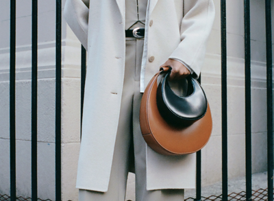 a woman holding two handbags 