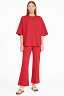 Red capsule top on model, crew neck, loose fit with short wide sleeves