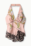 Pink silk halter top on hanger with multi-color print and ruffled hem