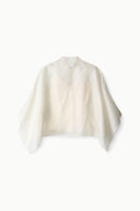 Ivory high-neck top with draped cape sleeves and subtle seam detailing