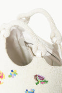 Off-white beaded tote bag with braided handles and visible zip pocket inside