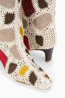 Close-up of tall suede patchwork boot fabric with cream lace-like trim and heart cutouts