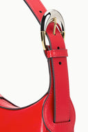 Red leather strap attachment with metal clasp and stitched panel