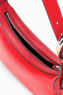 Red hobo bag with black zipper pocket and gold zipper pull