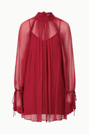 Pomegranate red sheer high-neck mini dress with pleated yoke and gathered sleeve cuffs