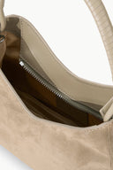 Beige suede shoulder bag with top zipper and stitched leather trim, open interior view