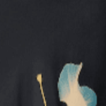 Close-up of black silk fabric with blue and gold botanical floral motif