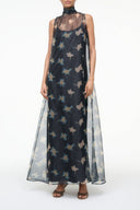 Sheer black botanical print maxi dress with sleeveless high neck and flowing skirt