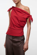 Red draped one-shoulder top with tie-knot detail at the shoulder