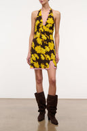 Black mini halter dress with yellow daisy floral print, sleeveless V-neck.