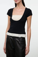 Black short-sleeve top with ivory scoop neckline ruffle and peplum hem