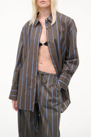 Navy vertical-striped button-up top with long sleeves and front placket
