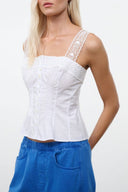 White sleeveless corset-style top with lace trim and button front