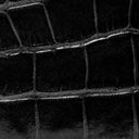 Close-up of black croc-embossed leather texture on a bag